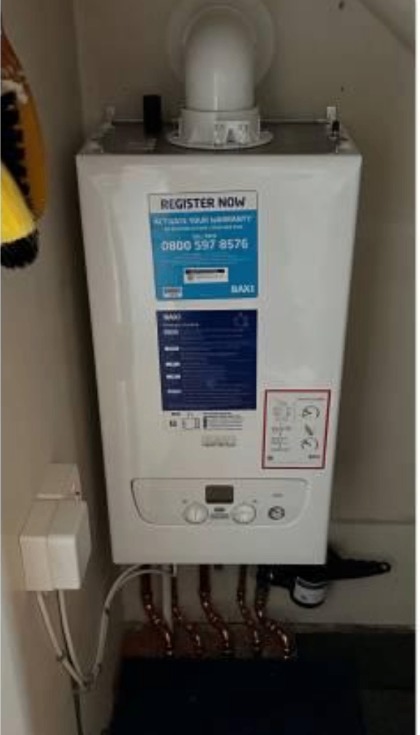 New boiler in a bare cupboard after